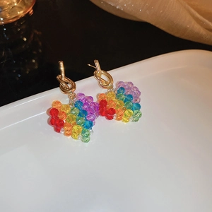 Vue détaillée de boucles d'oreilles cœur en perles colorées avec crochets dorés torsadés