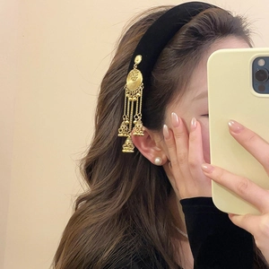 Ethnic style black velvet headband with golden fringe pendants and pearl earrings on model