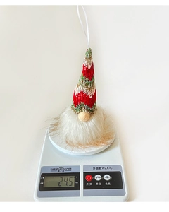 Detail view of a lighted Christmas gnome with knitted hat and 24.5g weight on a scale