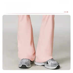 Gros plan de l'ourlet du pantalon de yoga rose évasé avec des baskets rétro