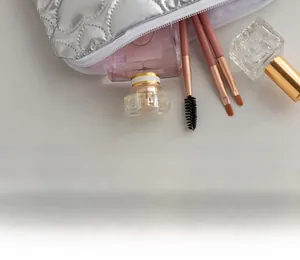 Silver quilted PU makeup bag showing spacious interior with cosmetic brushes and perfume