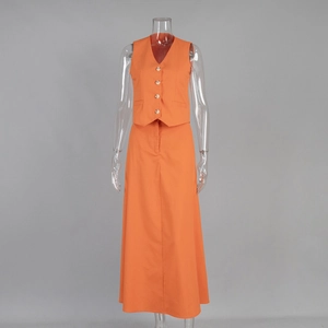 Detail of orange V-neck buttoned vest and high-waist maxi skirt set on a mannequin