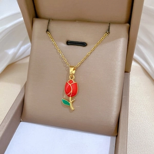 Close-up of golden rose flower pendant necklace in jewelry gift box with satin