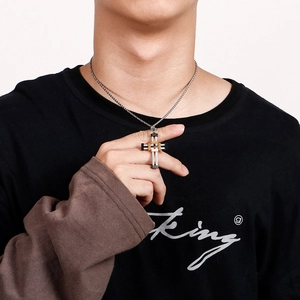 Detail of silver and gold punk cross pendant with mechanical gears worn on model neck