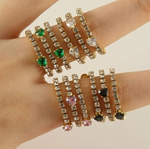Detail of stacked gold rings with colorful heart-shaped gems and micro-pave zircons