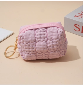 Detailed close-up of pink waffle texture coin purse with gold ring and smooth zipper