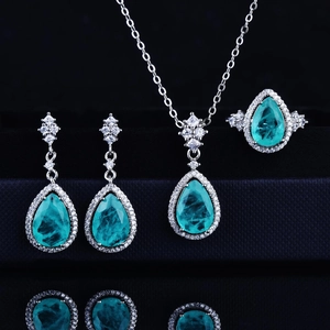Close-up of luxury pear-cut Paraiba blue gemstone necklace, earrings, and ring set