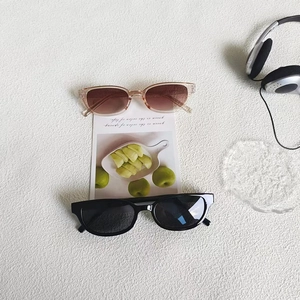 Detail view of pink and black square sunglasses on a white textured background