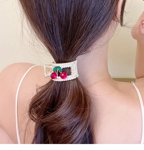 Détail de la pince à cheveux cerise avec perles blanches et cristaux rouges