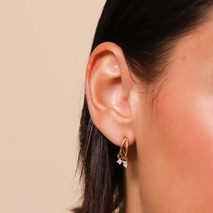 Elegant gold double hoop earrings with hanging clear zircon crystals on female model