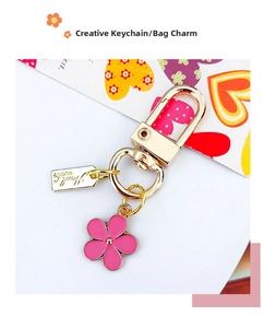 Macro view of pink flower keychain pendant with a gold Handmade tag and lobster clasp