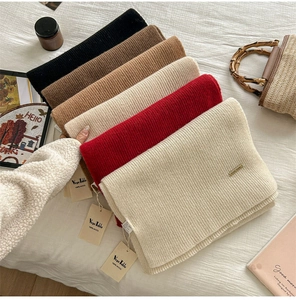 Detail of 100% pure wool scarves in various colors with chunky ribbed knit texture