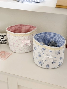 Quilted fabric storage baskets with lace trim and bow details for desktop organization