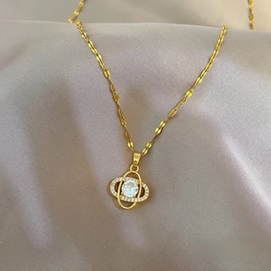 Luxurious gold clover hollow necklace with sparkling zircons on elegant grey silk