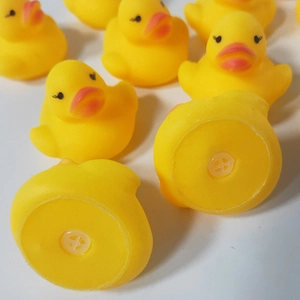 Detail view of the squeaky bottom hole on mini yellow rubber bath ducks for kids