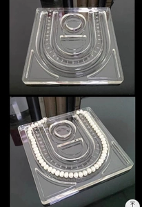 Detailed macro view of acrylic jewelry bead board with U-shaped sizing grooves