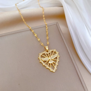 Gold heart necklace with phoenix wings and pavé diamonds on silk jewelry box