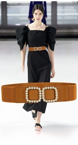 Detail of a brown elastic waist belt featuring an elegant double square pearl buckle