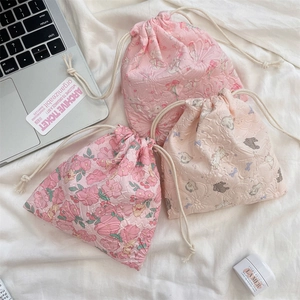 Close-up of pastel textured drawstring pouches with rabbit patterns and cotton cords