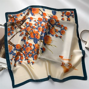 Detail of silk square scarf featuring orange floral patterns and a cute cat design