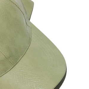 Close-up of light green baseball cap showing faux snakeskin texture and neat stitching details