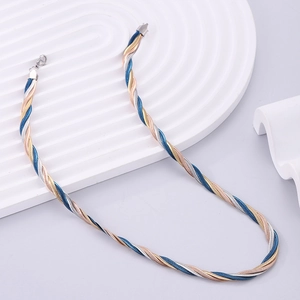 Close-up of tricolor braided snake chain necklace in gold silver and blue steel