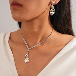 Détail du collier et des boucles d'oreilles cœur en cristal irisé sur mannequin