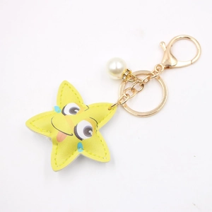 Yellow leather star keychain with cartoon face and pearl rhinestone charm on golden ring