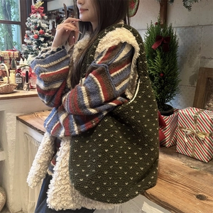 Détail du sac cabas en peluche vert foncé à cœurs dans un décor de Noël chaleureux