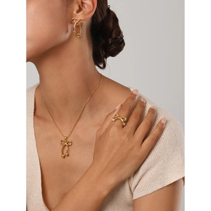 Golden bow jewelry set with stainless steel necklace, earrings and ring on model