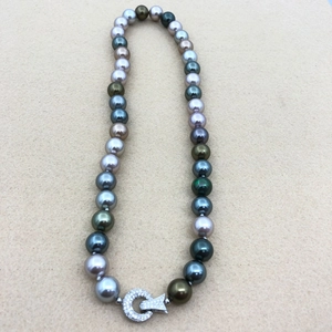 Detail shot of multi-colored Tahitian style pearls with a crystal-studded silver clasp