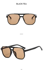 Detail view of double-bridge aviator sunglasses in black frame and tea lenses