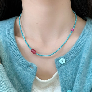 Beaded necklace with turquoise round beads and rose pink stones on female model