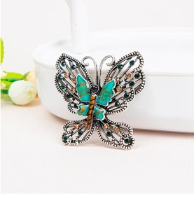 Detailed view of vintage butterfly brooch with teal enamel and colorful crystal inlay