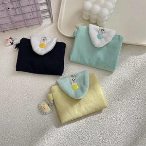 Detailed view of colorful fabric card holders with plush flaps and cute animal charms