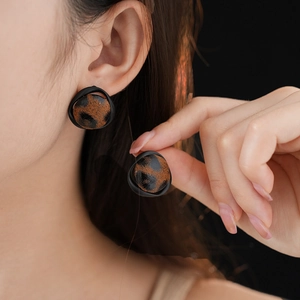 Gros plan sur des boucles d'oreilles rondes vintage à imprimé léopard en similicuir