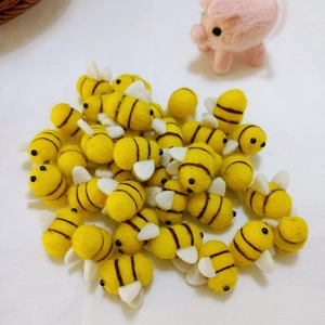 Close-up of handmade yellow and black wool felt bees for DIY craft and accessory projects
