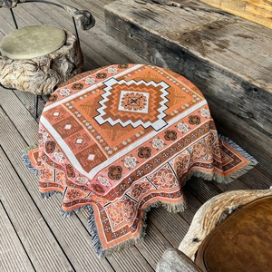 Detail of bohemian woven blanket with geometric diamond patterns and fringe tassels