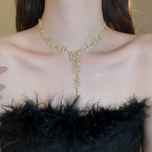 Détail d'un collier feuille de blé dorée avec diamants porté par un mannequin femme