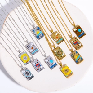 Detail of gold and silver tarot card necklaces with Sun and Moon motifs on a tray
