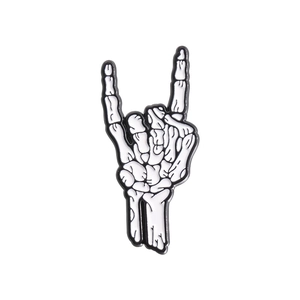 Detailed close-up of a white skeleton hand bone rocker sign metal enamel pin brooch