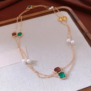 Vintage style layered gold chain necklace featuring colorful gemstones and white pearls
