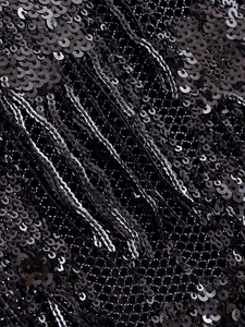 Gros plan détaillé sur les paillettes noires et les franges du tissu en maille