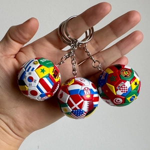 Close-up detail van een WK-thema sleutelhanger met drie mini nationale vlag voetbalballen.