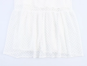 Detailed macro view of white mesh lace fabric texture and diamond pattern on dress hem
