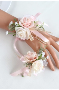 Dettaglio del corsetto da polso con rose rosa e bianche e nastri di raso per matrimoni