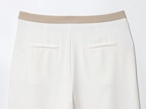Detailed view of white trouser waist with khaki contrast panel and welt pocket craft