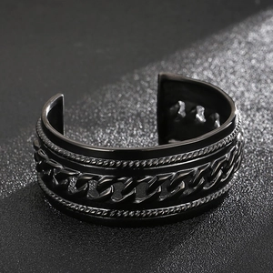 Close-up of black punk titanium steel cuff with woven texture and vintage chain details