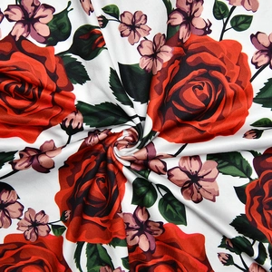Detail of vibrant red rose floral print on white elastic fabric for summer dress