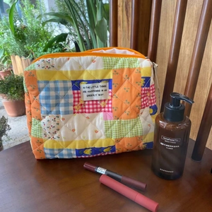 Detailed shot of a colorful quilted floral makeup bag with a stylish vintage label